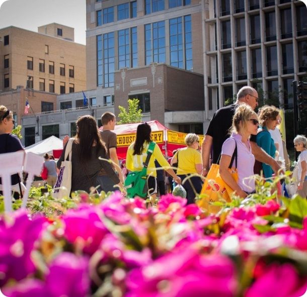 A group of people enjoying a farmers market. 