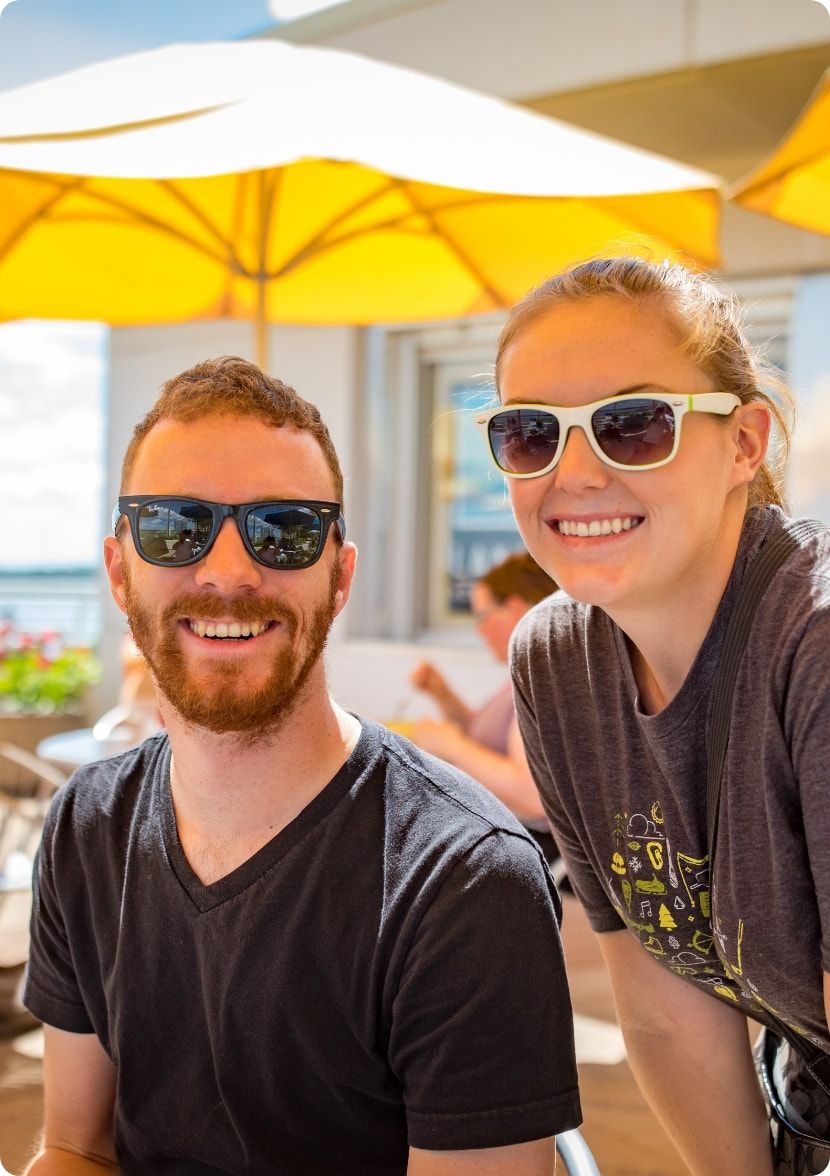 Two folks smiling on a sunny day.