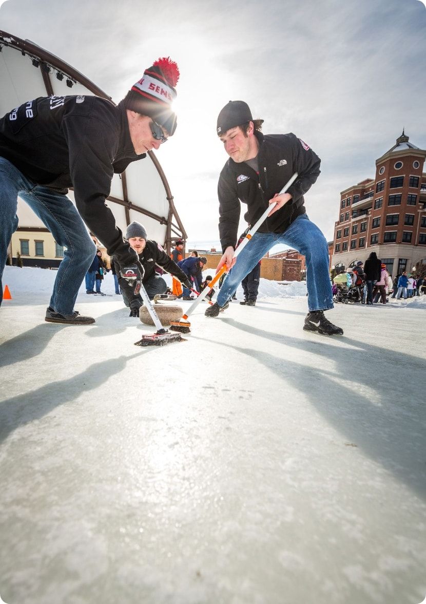 A group of guys curling.