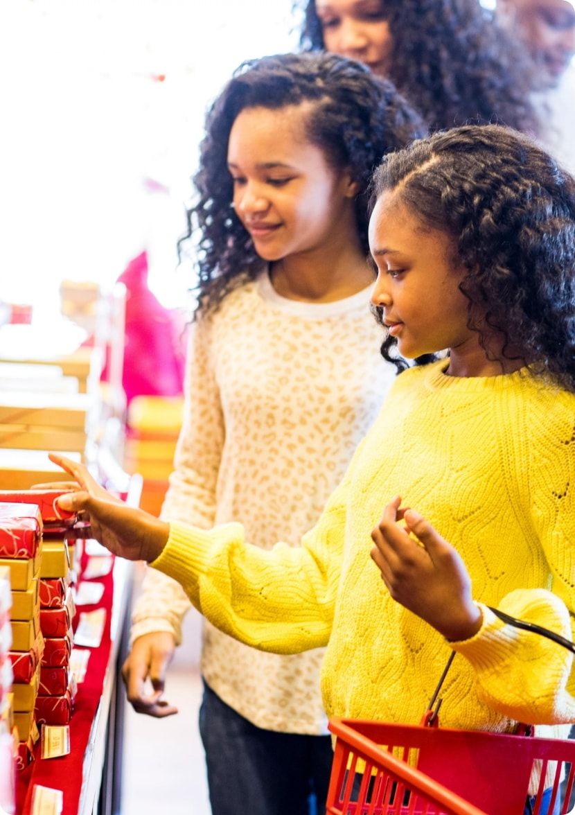 Two girls shopping with their mom. 