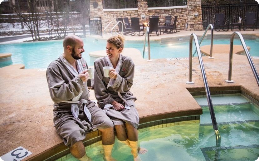 A couple sitting next to the hot tub.