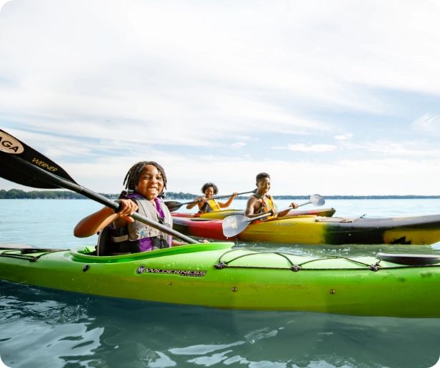 A family paddles in their kayaks. 