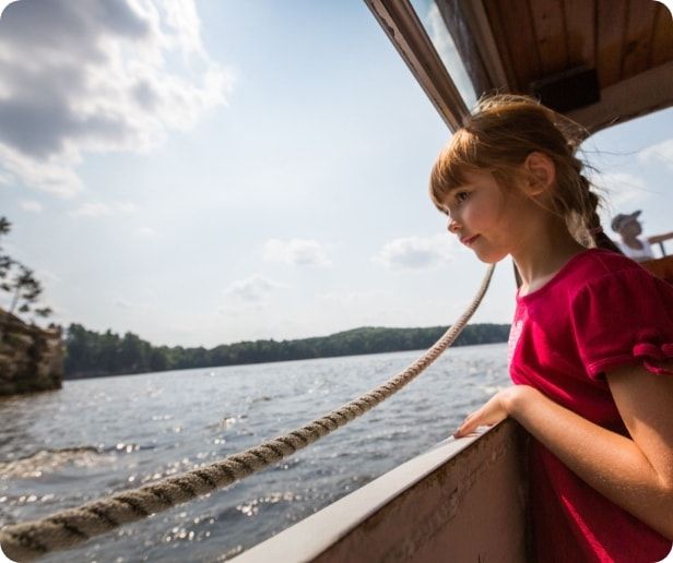 A girl looking out at the lake from a duck boat.