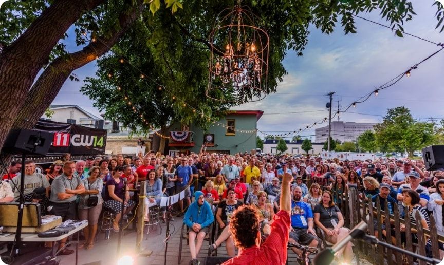 A view of a crowd enjoying an outdoor concert. 