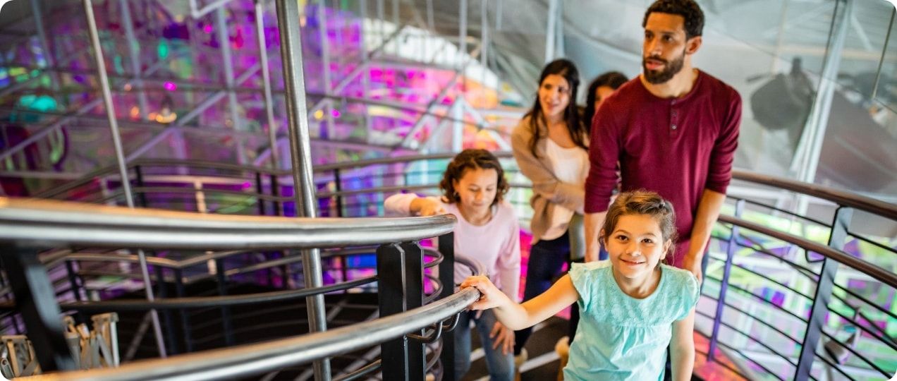 A family climbing the stairs in a museum. 