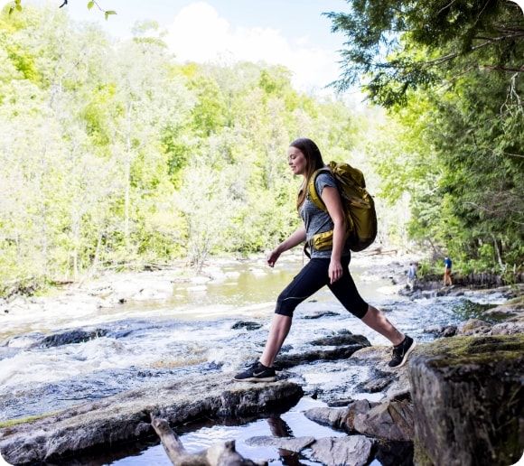 A hiker crossing the river. ¬  